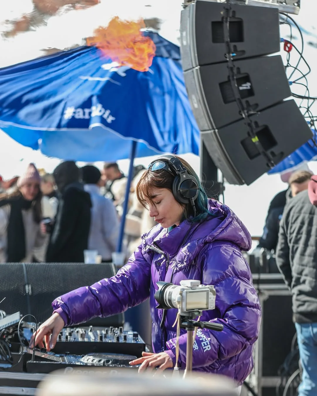 DJ kabininde performans veren bir sanatçı, arka planda ses sistemi