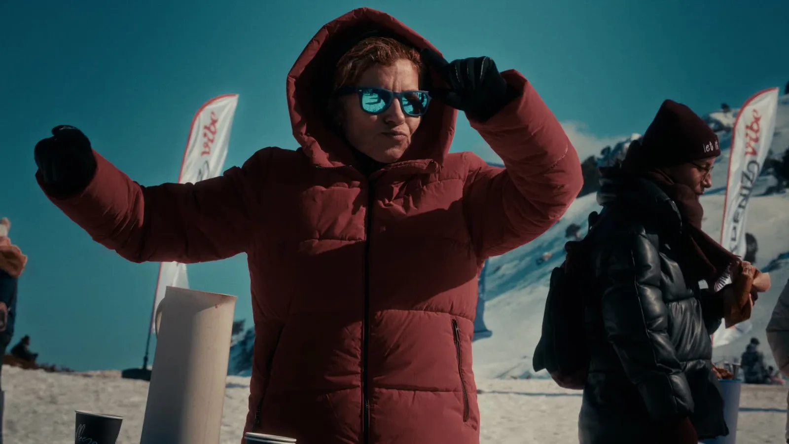 Saklıkent Kayak Merkezi'nde Akdeniz Winterfest katılımcıları, arkada karlı zirve ve festival bayrakları